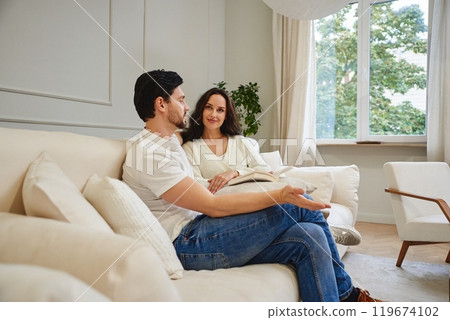 Couple engaged in a deep conversation inside a cozy living room 119674102
