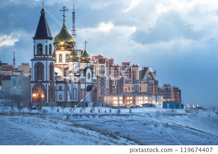 Winter landscape features an Orthodox Church with a snowy backdrop and city skyline 119674407