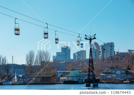 Old cable car in Dnepropetrovsk. Cable car cabins against the background of the blue sky and the urban landscape. Old cable car in Dnepropetrovsk. Cable car cabins against the background of the blue sky and the urban landscape. 119674443