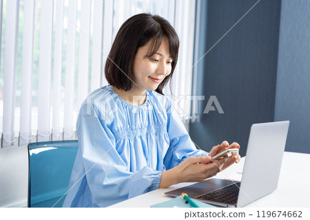 開啟電腦並操作智慧型手機的女性 07 119674662