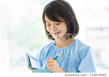 Woman taking notes while thinking 01 Woman taking notes while thinking 01 119674683