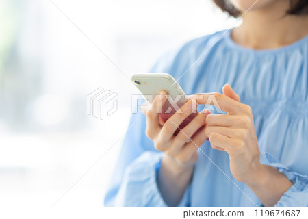 Stylish woman operating a smartphone 02 119674687
