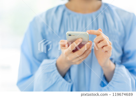 Stylish woman operating a smartphone 05 119674689