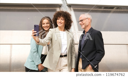 Happy businesswoman taking selfie with coworkers in city 119674762