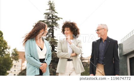 Happy business people discussing while walking in city Happy business people discussing while walking in city 119674772