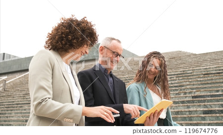 Happy business people using tablet near steps in city 119674776