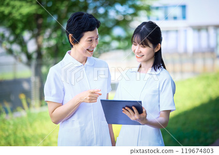 Nurses having a meeting while looking at medical records 119674803