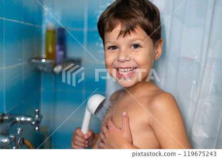 A child smiles while taking a shower. A child smiles while taking a shower. 119675243