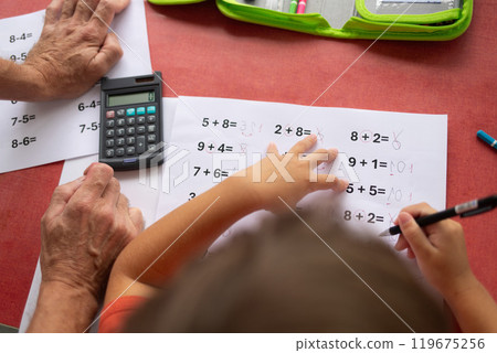 Over the shoulder view of a child who has dyslexia and dyscalculia doing math homework. 119675256