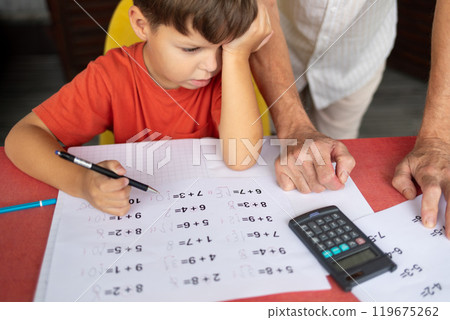 A six-year-old boy with dyscalculia and dysgraphia tries to complete his math homework. A six-year-old boy with dyscalculia and dysgraphia tries to complete his math homework. 119675262