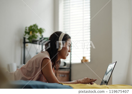 Listening to Music on Headphones While Working on Laptop Listening to Music on Headphones While Working on Laptop 119675407