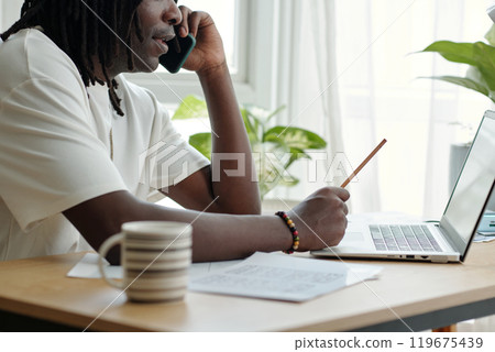 Engaging in a Phone Conversation While Using Laptop 119675439