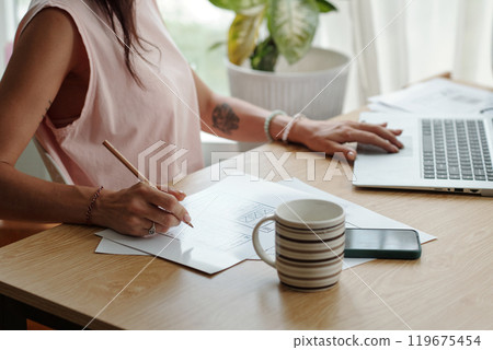 Woman Drawing Sketch at Wooden Workspace Desk 119675454