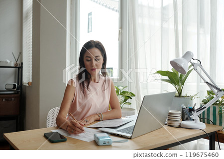 Focusing on Work at Modern Home Office Desk Focusing on Work at Modern Home Office Desk 119675460