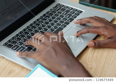 Hands Typing on Laptop Keyboard at Wooden Desk Hands Typing on Laptop Keyboard at Wooden Desk 119675489