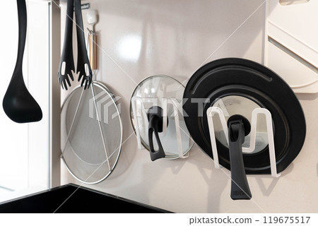 Cooking utensils hanging on the kitchen wall Cooking utensils hanging on the kitchen wall 119675517