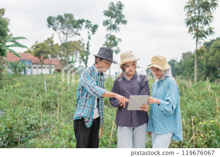 Farmers are Collaborating with Innovative Technology in a Beautiful Green Field Farmers are Collaborating with Innovative Technology in a Beautiful Green Field 119676067