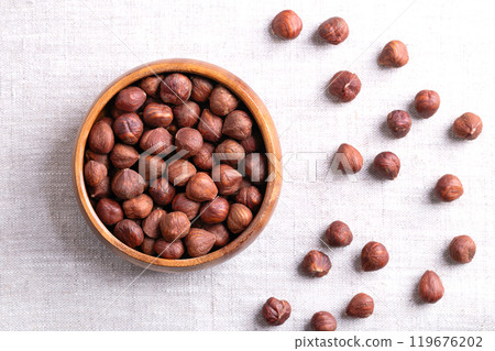 Hazelnut kernels, also known as cobnuts and filberts, in a wooden bowl on linen. Whole, dried and shelled nuts, fruits of the hazel tree Corylus avellana. Ready to eat as snack ,and to use for baking. Hazelnut kernels, also known as cobnuts and filberts, in a wooden bowl on linen. Whole, dried and shelled nuts, fruits of the hazel tree Corylus avellana. Ready to eat as snack ,and to use for baking. 119676202