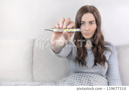 Woman shows mercury thermometer with a temperature of 37,7 C. Copy space photo Woman shows mercury thermometer with a temperature of 37,7 C. Copy space photo 119677318