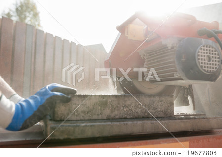 Close up view of a building contractor using an angle grinder or circular saw outdoors Close up view of a building contractor using an angle grinder or circular saw outdoors 119677803