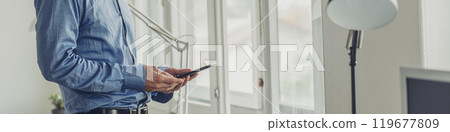 Businessman using digital tablet by office windows 119677809