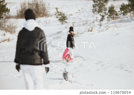 Family on family Christmas vacation. Woman and little girl in a forest. People walks. 119678054