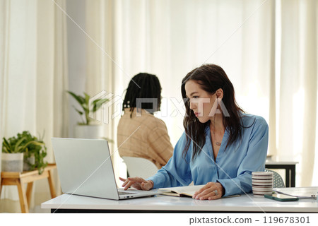 Collaborating at Modern Office Workspace with Laptops 119678301