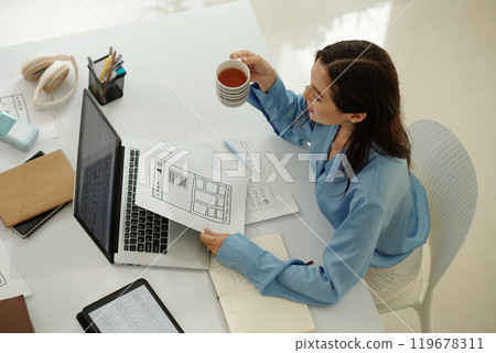 Businesswoman Reviewing Digital Documents with Coffee 119678311