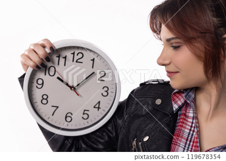 A woman confidently holding a stylish clock while dressed in an elegant and modern attire A woman confidently holding a stylish clock while dressed in an elegant and modern attire 119678354