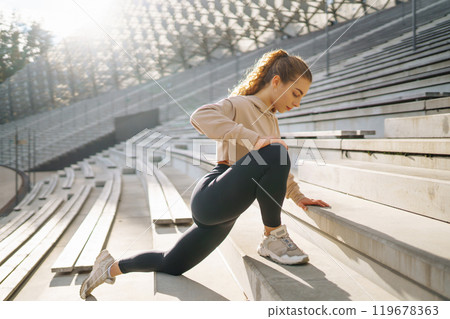 Fitness woman in fashionable sportswear is doing sports outdoors. The concept of active lifestyle. 119678363