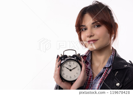A Young Woman Dressed in a Stylish Outfit is Holding an Alarm Clock with Confidence and Charm 119678428