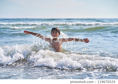 An 11 year old boy in having fun in the sea waves. An 11 year old boy in having fun in the sea waves. 119678529