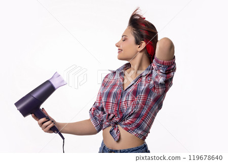 A Stylish Woman Using a Hair Dryer for a Stunning Hair Makeover in a Chic and Vibrant Studio A Stylish Woman Using a Hair Dryer for a Stunning Hair Makeover in a Chic and Vibrant Studio 119678640