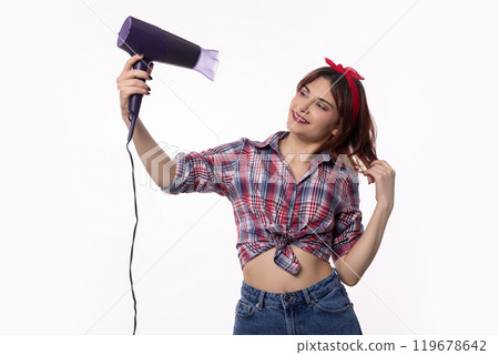 A Stylish Woman Holding a Hair Dryer While Wearing a Trendy and Fashionable Outfit 119678642