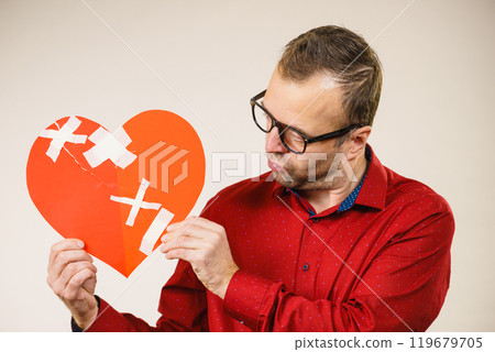 Adult man holding broken heart 119679705
