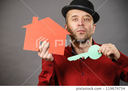 Man holding red house model and home keys 119679734