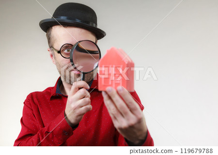 Man magnifying red house 119679788