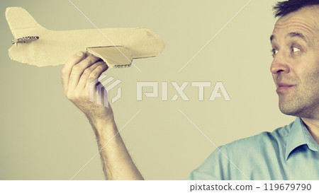 Fly fear. Man holding airplane in hand Fly fear. Man holding airplane in hand 119679790