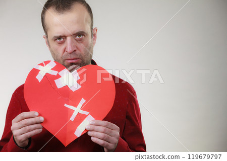 Sad adult man holding broken heart Sad adult man holding broken heart 119679797