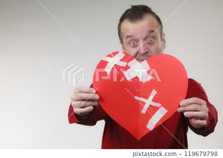 Funny man holds broken heart 119679798