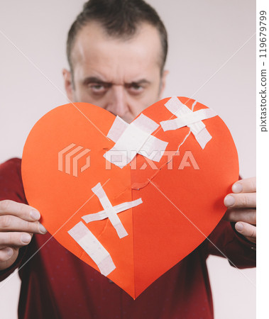 Funny man holds broken heart 119679799