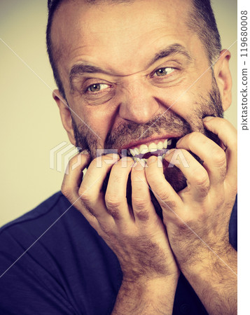 Man biting his nails Man biting his nails 119680008