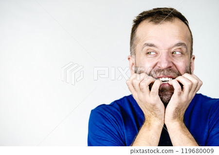 Scared adult man biting nails Scared adult man biting nails 119680009