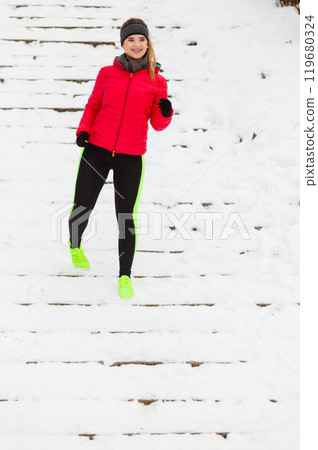 Woman wearing sportswear exercising outside during winter Woman wearing sportswear exercising outside during winter 119680324