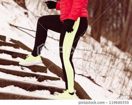 Woman wearing sportswear exercising during winter Woman wearing sportswear exercising during winter 119680350