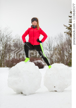 Woman wearing sportswear playing on snow Woman wearing sportswear playing on snow 119680377