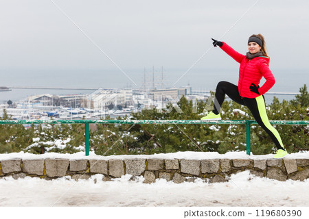 Woman wearing sportswear exercising during winter Woman wearing sportswear exercising during winter 119680390