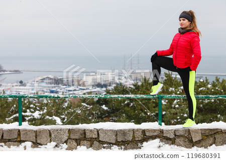 Woman wearing sportswear exercising during winter Woman wearing sportswear exercising during winter 119680391