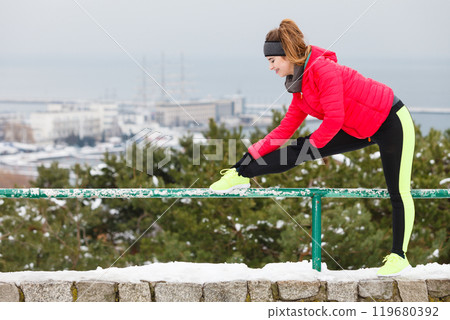 Woman wearing sportswear exercising during winter Woman wearing sportswear exercising during winter 119680392