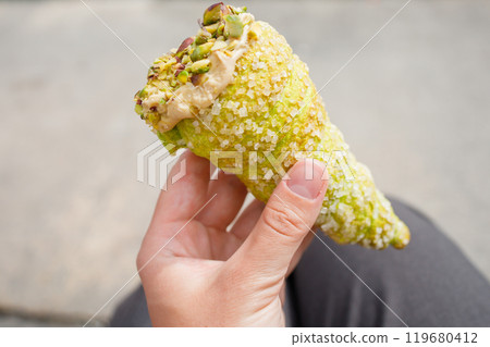 Pistachio cannoli from Malta in hand close up Pistachio cannoli from Malta in hand close up 119680412